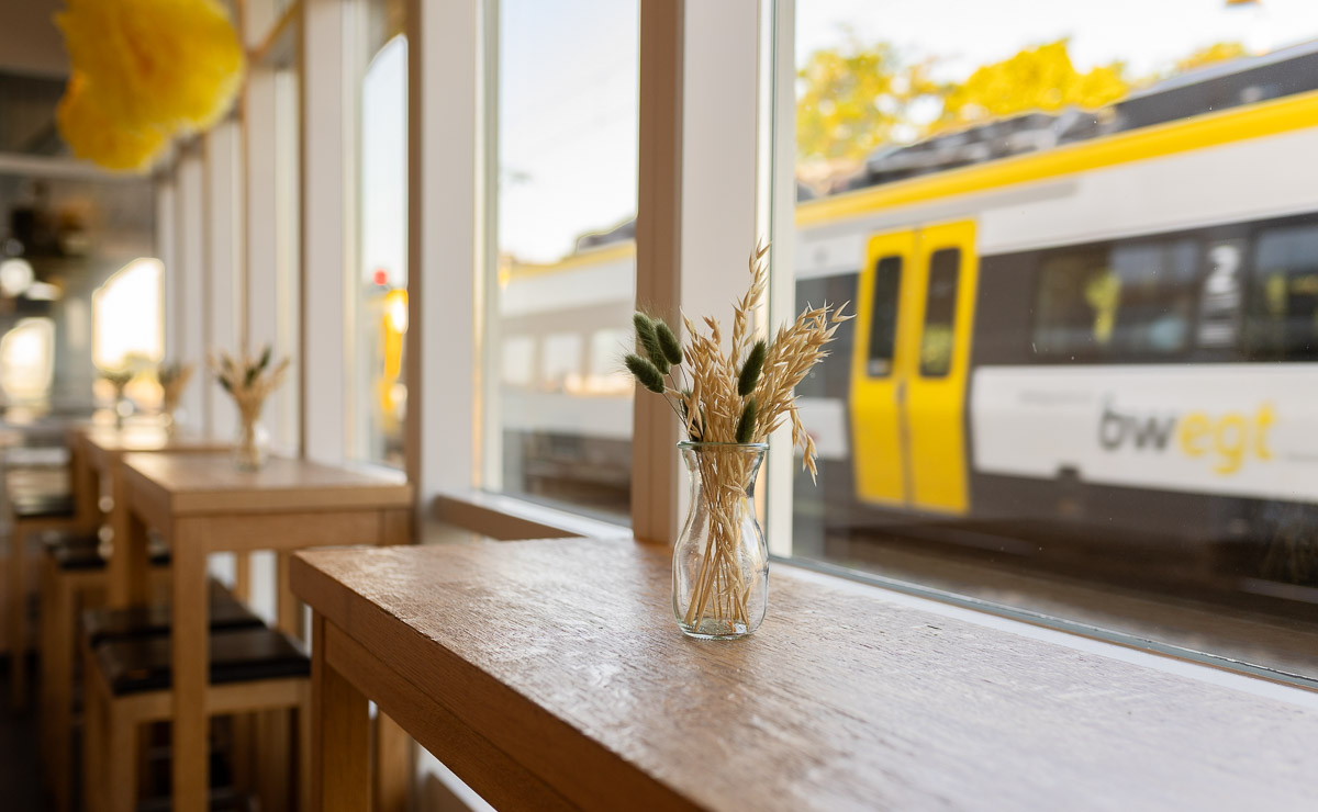 Sitzbereich mit Sicht auf Bahngleise in der Kaisers Gute Backstube Filiale Heitersheim dBahnhof